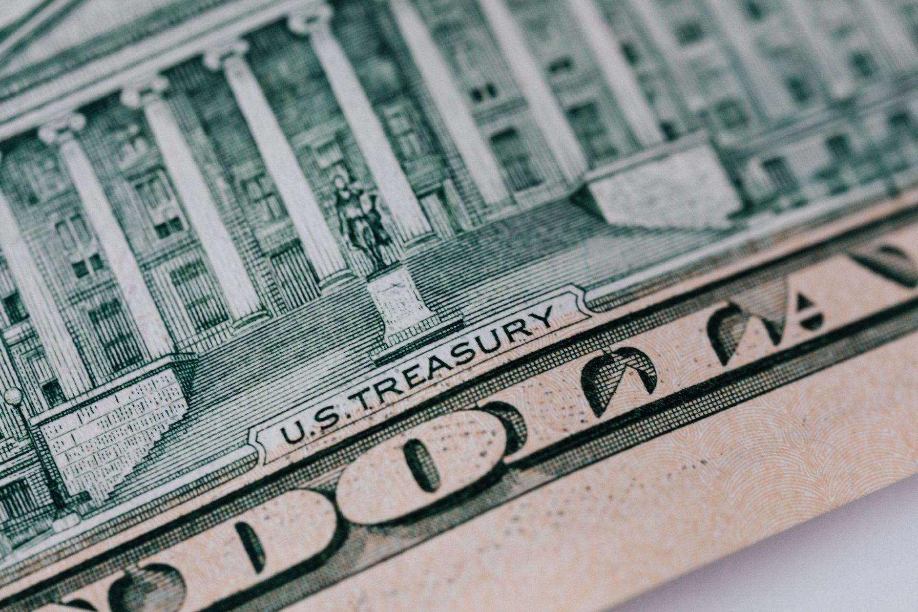 From above ten dollar banknote with inscription and United States treasury building placed on table